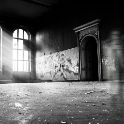 Black and white interior of a historic home with a shadowy figure, representing fear, spirits, and the power of the living.