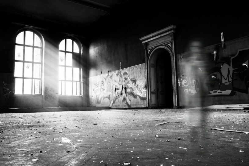 Black and white interior of a historic home with a shadowy figure, representing fear, spirits, and the power of the living.