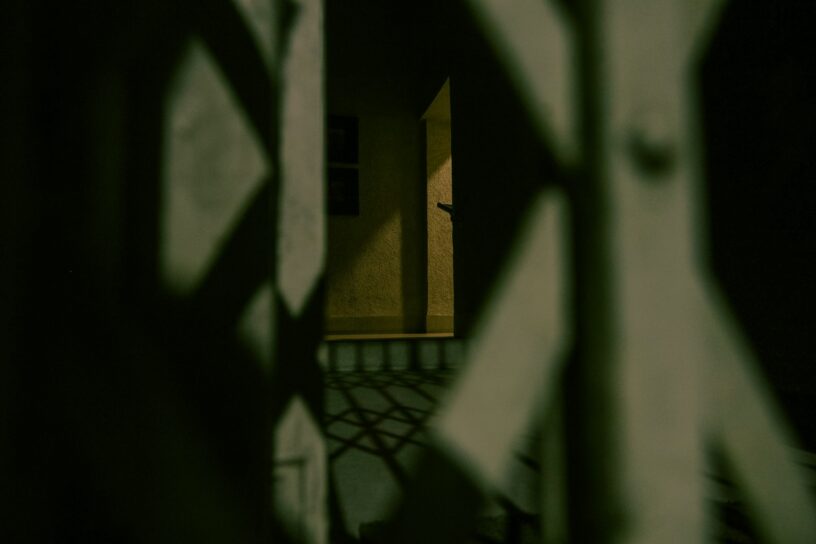 Shadowy figure in a dark basement representing spirits hiding during a paranormal investigation