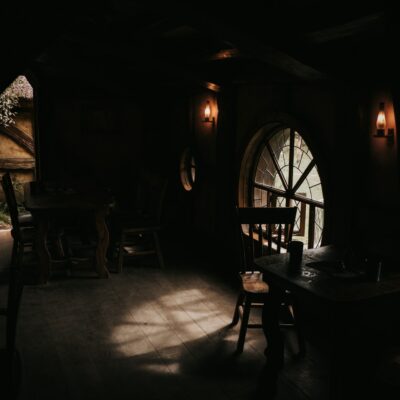 Open door inside a small cottage with a table and stool near the window