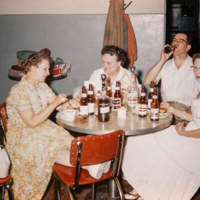 Vintage photograph of friends gathered around a table, representing the personalities spirits carry from life